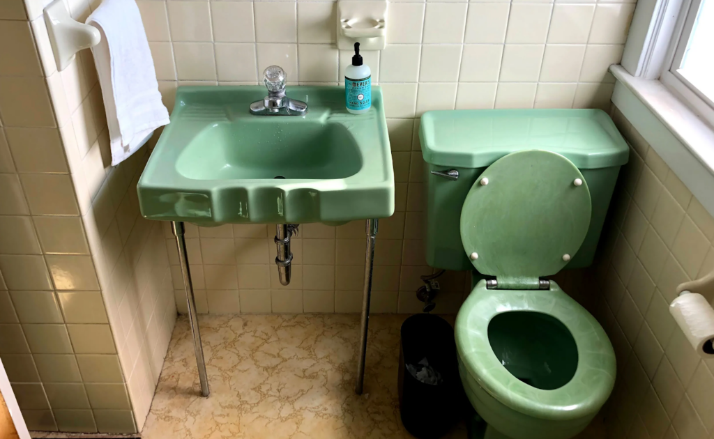 Photo of a vintage green sink and toilet before a ZINTEX bathroom remodel